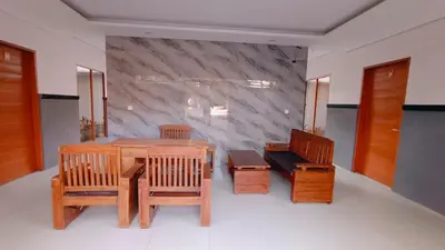 a room with a table and chairs and a marble wall at Deva Guest House - Kerobokan in Seminyak