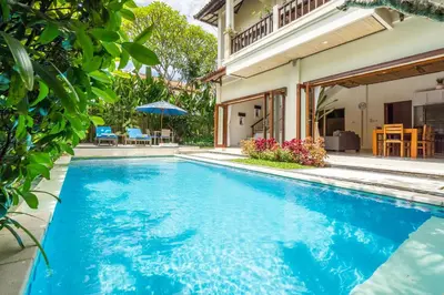 a swimming pool in front of a house at Tropical Villas - 2 Bed & 3 Bed in Kerobokan