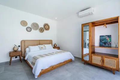 a bedroom with a large bed and a mirror at 3Br New Private Family Villa- Sanur in Sanur