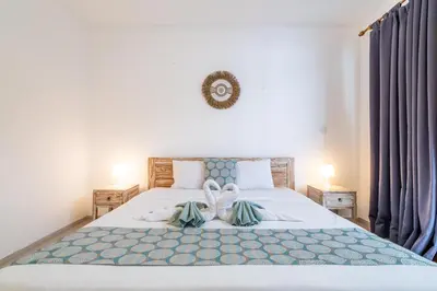 a bedroom with a large white bed with blue sheets at Villa Azure 3 - Private Suite in Shared Tropical Pool Villa in Seminyak