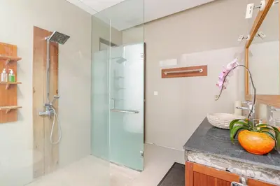 a bathroom with a glass shower and a sink at Villa Stephana Edge of Seminyak in Canggu