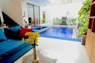 a living room with a couch and a swimming pool at Villa Stephana Edge of Seminyak in Canggu