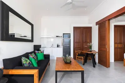 a living room with a black couch and a table at Gorgeous 1 Bed Pool Villa, Walk to Beach, Shops in Seminyak