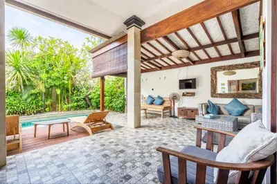an outdoor living room with a pool and a house at Just a 3 min stroll to the Seminyak beach in Badung