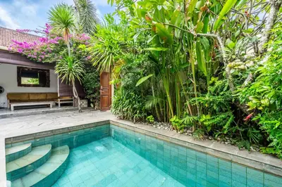 a swimming pool in front of a house with plants at Just a 3 min stroll to the Seminyak beach in Badung