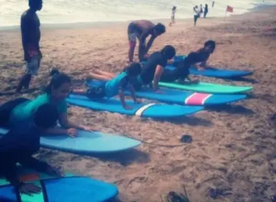 a group of people laying on their surfboards on the beach at inadreadboy surfclass in Legian