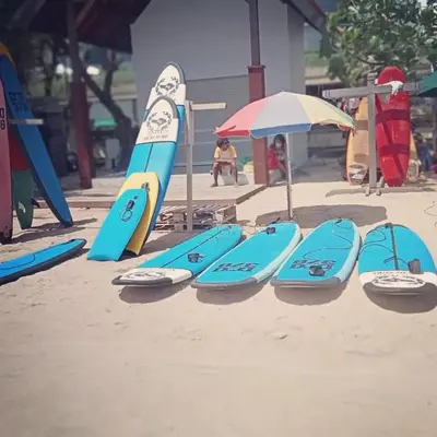 a group of surfboards are lined up in the sand at inadreadboy surfclass in Legian