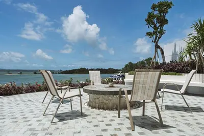 a patio with a table and chairs and the water at Stunning Sea Front Villa 4BR Nusa Dua in Badung