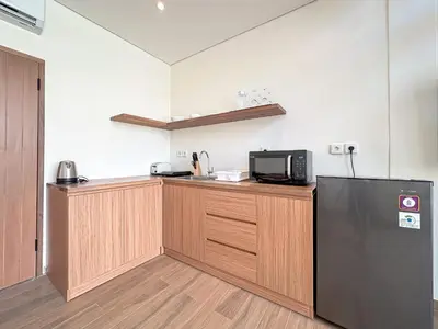a kitchen with a refrigerator and a microwave at Olala Loft Seminyak in Seminyak