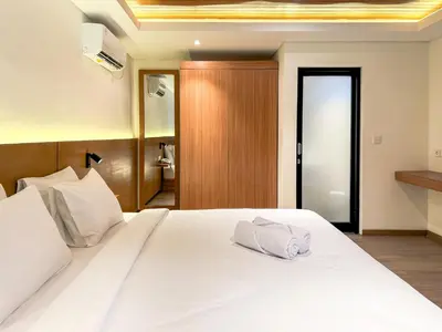 a large white bed with a towel on it at Olala Loft Seminyak in Seminyak