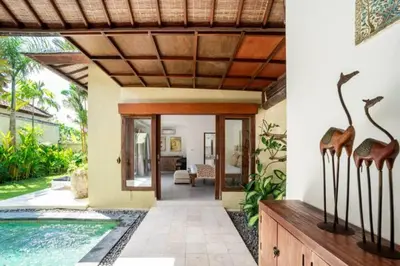 a home with a swimming pool and a house with giraffe statues at Villa Shanti, Sitara Villa Group in Seminyak