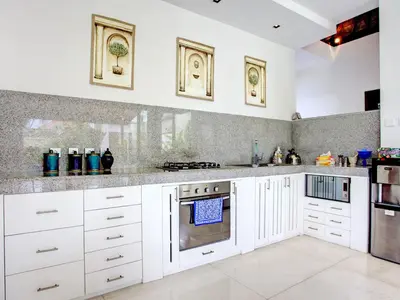 a kitchen with white cabinets and stainless steel appliances at Villa Shanti, Sitara Villa Group in Seminyak