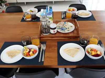 a table with plates of food and cups of orange juice at Villa Shanti, Sitara Villa Group in Seminyak