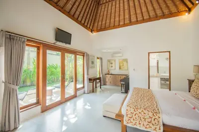 a bedroom with a bed and a living room at Villa Shanti, Sitara Villa Group in Seminyak