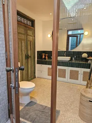 a bathroom with a toilet and a sink and a mirror at Villa Gamelan Bohème Chic Bali in Seminyak