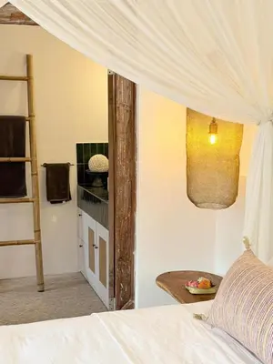 a bedroom with a bed with a white canopy at Villa Gamelan Bohème Chic Bali in Seminyak