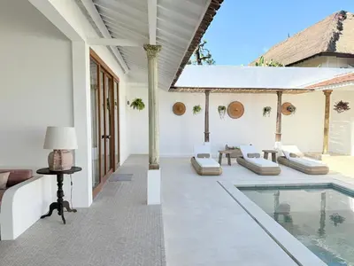 an outdoor patio with a pool and a table and chairs at Villa Gamelan Bohème Chic Bali in Seminyak