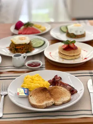 a table with plates of breakfast food on it at Villa Taman Rahasia, Sitara Villa Group in Seminyak