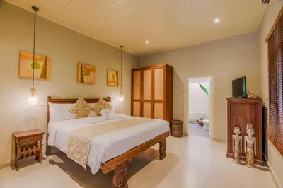 a bedroom with a bed and a tv in it at Villa Taman Rahasia, Sitara Villa Group in Seminyak