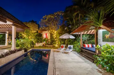 a backyard with a swimming pool at night at Tropical Oasis of Calm in the Heart of Seminyak, 4BR Villa Luisha in Seminyak