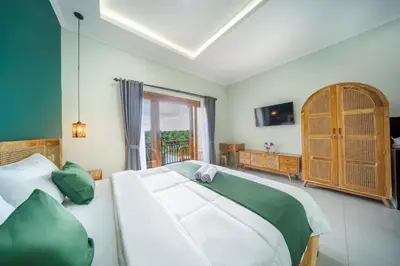 a bedroom with a large white bed and a window at D'Gangga Residence By Bali Cabin in Kerobokan