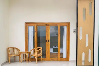 a wooden door with two chairs and a table at D'Gangga Residence By Bali Cabin in Kerobokan