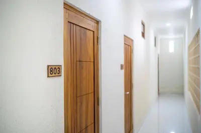 an empty hallway with a door and a clock on the wall at D'Gangga Residence By Bali Cabin in Kerobokan