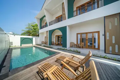 a house with a swimming pool and two chairs at D'Gangga Residence By Bali Cabin in Kerobokan