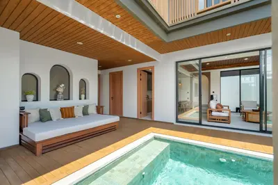 a bedroom with a bed and a swimming pool at Villa Loema in Kerobokan
