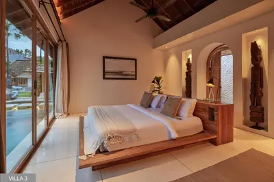 a bedroom with a bed and a large window at Villa Massilia Bali in Seminyak