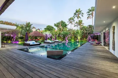 a swimming pool in a house with a wooden deck at Seminyak Luxueuse villa 61 BR 18 personnes in Seminyak