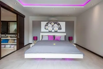 a bedroom with a large bed with purple lighting at Seminyak Luxueuse villa 61 BR 18 personnes in Seminyak