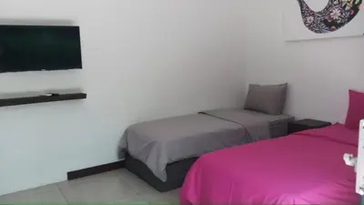 a bedroom with two beds and a flat screen tv at Seminyak Luxueuse villa 61 BR 18 personnes in Seminyak