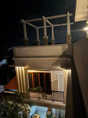 a white building with a balcony at night at Graha Shanti Guest House in Pulau Serangan