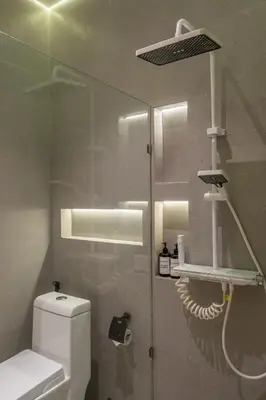 a bathroom with a toilet and a glass wall at 1BR Modern Loft near Airport in Pesanggaran