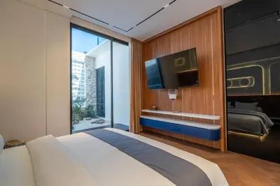 a bedroom with a large bed and a tv at 2BR Modern Suites near Airport in Pesanggaran