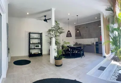 a living room with a table and a kitchen at Villa Casa Mari in Seminyak
