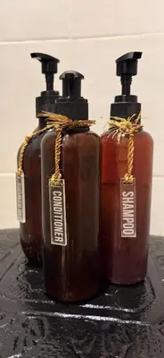 three bottles with tags on them sitting on a table at Villa Casa Mari in Seminyak