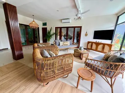 a living room with wicker furniture and a flat screen tv at Villa AYLA - Legian - 5 Bedrooms - 5 Bathrooms in Seminyak