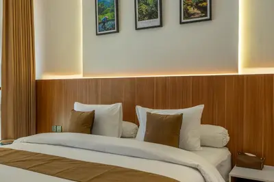 a bedroom with a large bed with a wooden headboard at 1BR Stylish Loft near airport in Pesanggaran