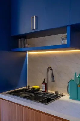 a kitchen with a sink and blue cabinets at 1BR Stylish Loft near airport in Pesanggaran