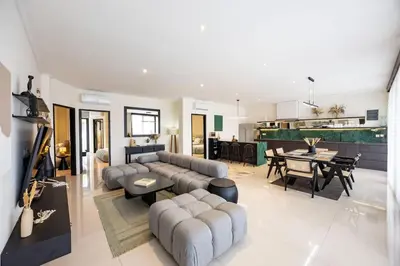 a living room with a couch and a dining room at Damai Suite Relax & Comfort in Canggu 3BR in Canggu