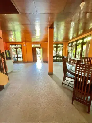 a room with chairs and a table in a building at Nyoman Legian House in Legian