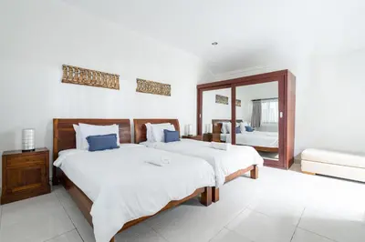 a bedroom with two beds and a mirror at Villa Vista 2 Seminyak in Seminyak