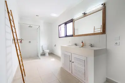 a bathroom with a sink and a toilet and a mirror at Villa Vista 2 Seminyak in Seminyak