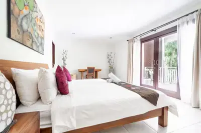 a white bedroom with a large bed and a window at Villa Vista 2 Seminyak in Seminyak