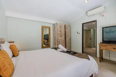 a bedroom with a white bed and a flat screen tv at Villa Vista 3 Seminyak in Seminyak