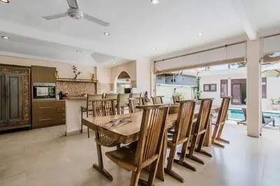 a kitchen and dining room with a wooden table and chairs at Villa Vista 3 Seminyak in Seminyak