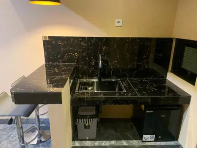 a black counter top with a sink in a kitchen at Pradantara House in Nusa Dua