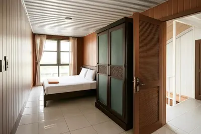 a small bedroom with a bed and a window at trees inn Bali Denpasar in Denpasar